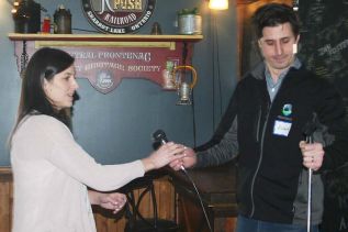 Frontenac County’s manager of economic development Richard Allen passes the mike to Ontario Highlands Tourism Organization tourism development coordinator Stephanie Hessel at the Sharbot Lake Country Inn Monday.